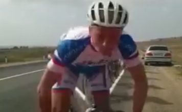 Ciclista concentrado na corrida bate num carro encostado na berma da estrada