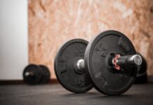 Rustic gym scene showing close-up of dumbbells for weight training.