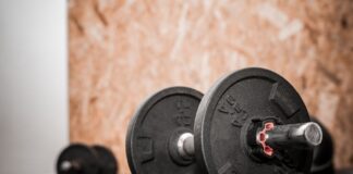 Rustic gym scene showing close-up of dumbbells for weight training.