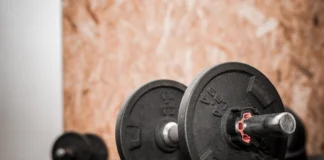 Rustic gym scene showing close-up of dumbbells for weight training.