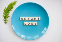 A blue plate with 'weight loss' tiles and a fern leaf on white background.