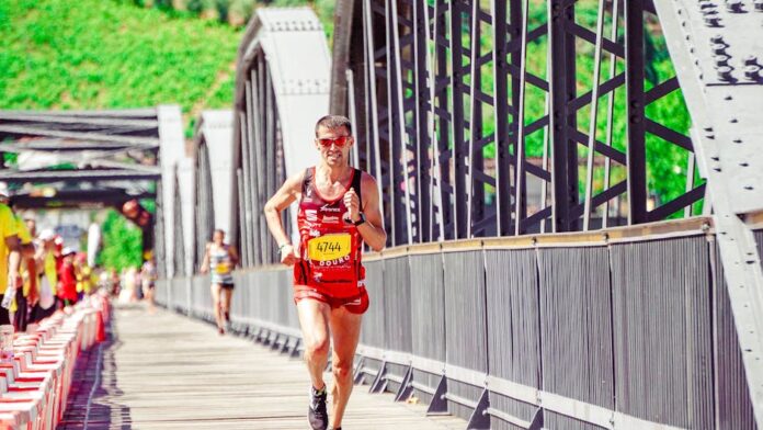 Runner in a bright marathon, displaying endurance and athleticism on a sunny day bridge course.