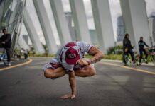 A person performing a yoga pose in an urban setting, surrounded by modern architecture.