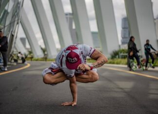 Como melhorar a flexibilidade com Yoga ou Pilates em 5 passos A person performing a yoga pose in an urban setting, surrounded by modern architecture.