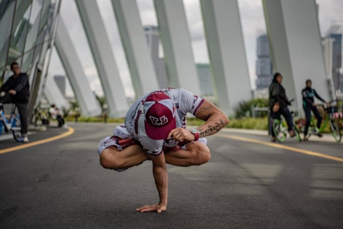 A person performing a yoga pose in an urban setting, surrounded by modern architecture.