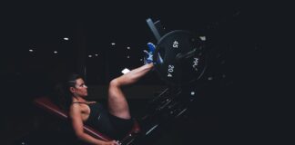 A woman engages in an intense leg press workout at the gym, showcasing strength and fitness.
