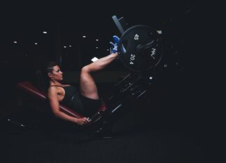 A woman engages in an intense leg press workout at the gym, showcasing strength and fitness.