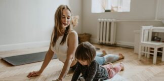 A mother and child practicing yoga together at home on a sunny day, fostering wellness and connection.