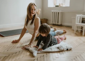 A mother and child practicing yoga together at home on a sunny day, fostering wellness and connection.