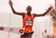 Runner crossing the finish line at a marathon in Lisbon, showcasing victory and achievement.