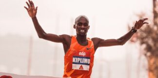 Runner crossing the finish line at a marathon in Lisbon, showcasing victory and achievement.