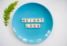 A blue plate with 'weight loss' tiles and a fern leaf on white background.