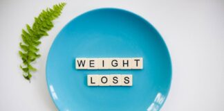 A blue plate with 'weight loss' tiles and a fern leaf on white background.
