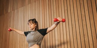 Caucasian woman in activewear lifting dumbbells for fitness training.