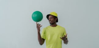 Tendências atuais no mundo do desporto que vão surpreender Portrait of a man in neon green clothing spinning a green ball indoors.