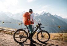 Equipamento essencial para ciclistas iniciantes: O que não pode faltar Cyclist with backpack enjoying a scenic mountain view in Saas-Fee, Switzerland.
