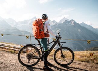 Cyclist with backpack enjoying a scenic mountain view in Saas-Fee, Switzerland.
