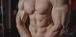 Treino de peito e tríceps para iniciantes Shirtless male bodybuilder showing muscular torso and defined arms in a gym setting.