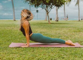 A woman practices yoga in a park, enjoying the outdoors. Perfect for wellness and fitness themes.