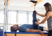 Centro de Saúde em Portugal: Descubra a sua importância Personal trainer assists amputee in rehabilitation exercise indoors.