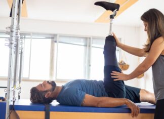 Centro de Saúde em Portugal: Descubra a sua importância Personal trainer assists amputee in rehabilitation exercise indoors.