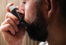 Cinesioterapia Respiratoria: Descubra os seus benefícios A close-up image of a man using an inhaler, highlighting respiratory health concepts.