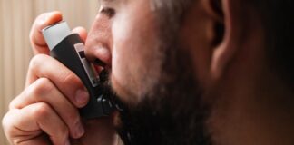 Cinesioterapia Respiratoria: Descubra os seus benefícios A close-up image of a man using an inhaler, highlighting respiratory health concepts.