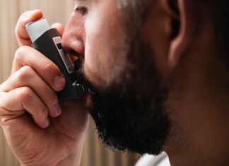 Cinesioterapia Respiratoria: Descubra os seus benefícios A close-up image of a man using an inhaler, highlighting respiratory health concepts.