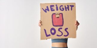 Como emagrecer de forma saudável com exercício: Dicas essenciais Person holding 'weight loss' sign for fitness motivation and health goals.
