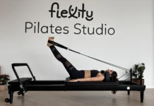 Descubra a melhor roupa para pilates e melhore o seu desempenho Woman performing pilates exercises on a reformer at Flexity Pilates Studio.