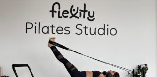 Woman performing pilates exercises on a reformer at Flexity Pilates Studio.