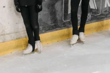 Leggings no Desporto: Descubra o conforto e estilo em cada movimento Two people on an ice rink wearing white ice skates and black leggings.