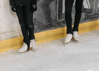 Leggings no Desporto: Descubra o conforto e estilo em cada movimento Two people on an ice rink wearing white ice skates and black leggings.