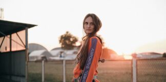 Macacão desportivo: Conforto e estilo para todas as atividades Side view of young contemplative female in skydiving jumpsuit with straps looking away on roadway against aerodrome at sunset