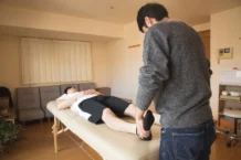 Massagem Fisioterapia: Descubra os benefícios incríveis A physiotherapist provides therapy to a male patient in a comfortable indoor setting.