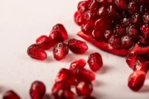Vida Saudável: 7 Segredos que transformam o seu dia a dia Vibrant close-up of juicy pomegranate seeds with droplets, ideal for healthy food concepts.