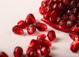 Vida Saudável: 7 Segredos que transformam o seu dia a dia Vibrant close-up of juicy pomegranate seeds with droplets, ideal for healthy food concepts.