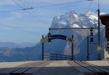 Scenic view of train station with Swiss Alps in the background. Perfect for travel enthusiasts.
