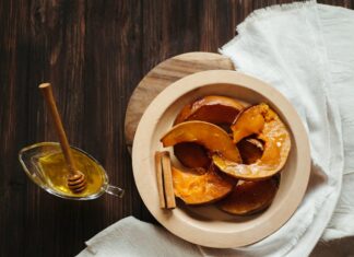 Delicious baked pumpkin slices with honey and cinnamon on a rustic wooden table.