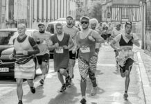 Corridas populares: Descubra os segredos dos campeões Participants in a fun run wearing various costumes on a city street. Energetic race scene.