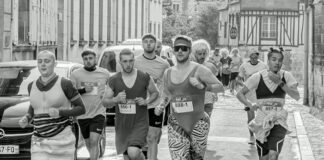 Corridas populares: Descubra os segredos dos campeões Participants in a fun run wearing various costumes on a city street. Energetic race scene.