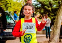 Descubra como as corridas solidárias estão mudando vidas Young girl participating in a vibrant marathon event, showing enthusiasm and energy.