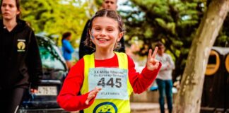 Young girl participating in a vibrant marathon event, showing enthusiasm and energy.