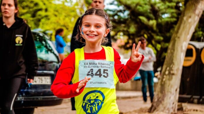 Descubra como as corridas solidárias estão mudando vidas! Young girl participating in a vibrant marathon event, showing enthusiasm and energy.