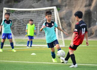 Desporto para Crianças: Atividades incríveis nas férias Boys playing soccer during a team training session outdoors on a sunny day.