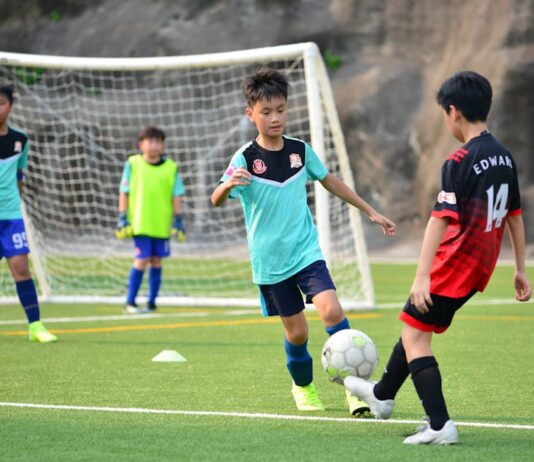 Desporto para Crianças: Atividades incríveis nas férias Boys playing soccer during a team training session outdoors on a sunny day.
