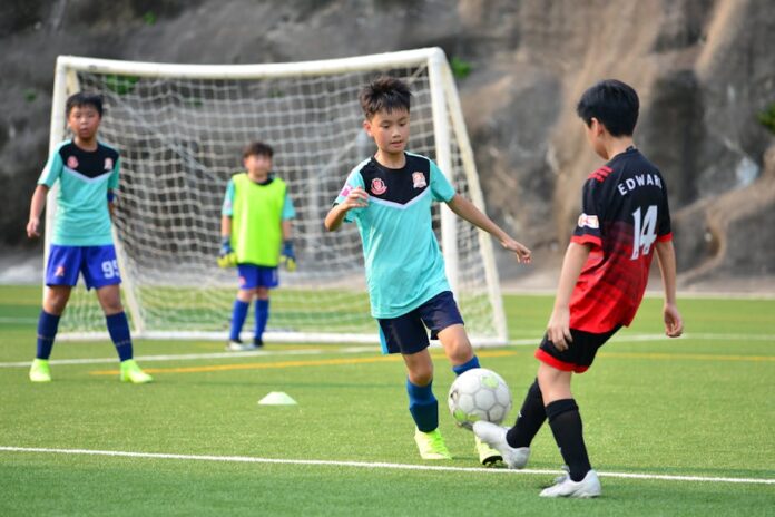 Desporto para Crianças: Atividades Incríveis nas Férias! Boys playing soccer during a team training session outdoors on a sunny day.