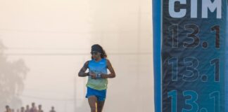 Meia Maratona: Dicas exclusivas e segredos Focused runner at California International Marathon with distance marker in soft light.