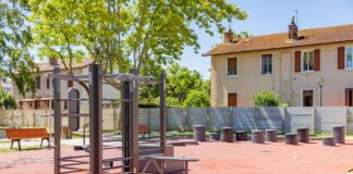 Public outdoor gym with exercise equipment in a sunny park in Saint-Priest, France.