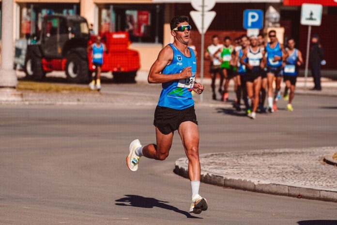 Treino para São Silvestre: Dicas Essenciais para Surpreender Dynamic image of a male athlete leading a marathon on a sunny day, showcasing determination and endurance.